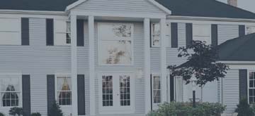 Picture of a large, white, two story house with black shutters.